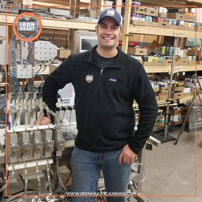 Mark, the VP of Special Projects and Services and creator of the technical support program, standing in front of a canning line
